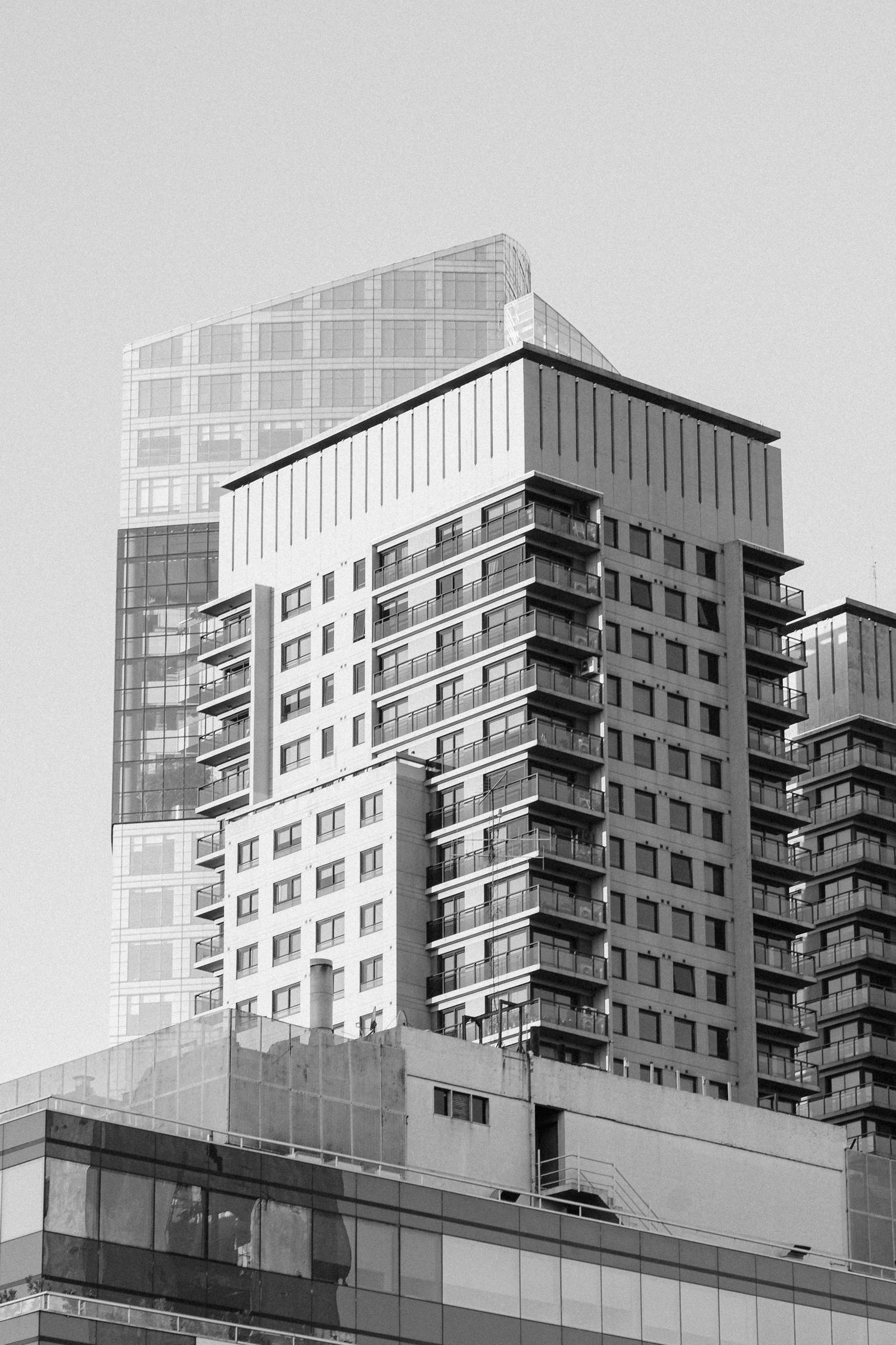 A black-and-white image showcasing modern high-rise buildings in an urban setting.