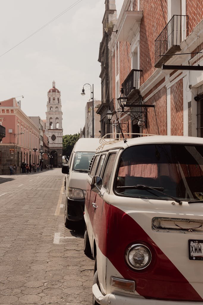 Vintage VW van parked on a scenic street in Heroica Puebla de Zaragoza, Mexico with colonial architecture.